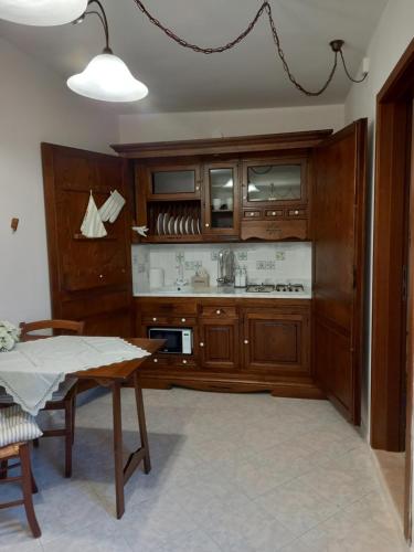 uma cozinha com armários de madeira e uma mesa em Mini alloggio rosmarino vicino alla porta Elisa em Lucca