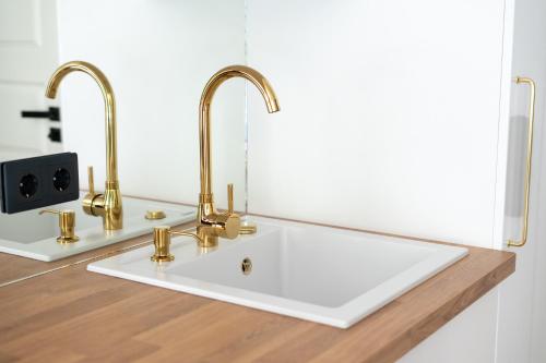 a bathroom sink with two faucets on a counter at Tallinn Oasis Studios by RevalHome in Tallinn