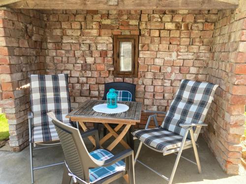 a patio with a table and chairs and a brick wall at Apartmány Chmelničky in Protivín