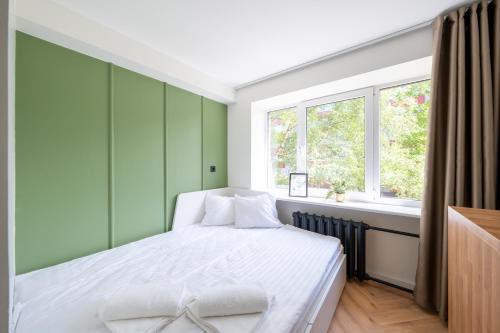 Un dormitorio con una cama con paredes verdes y una ventana en Tallinn Oasis Studios by RevalHome en Tallin