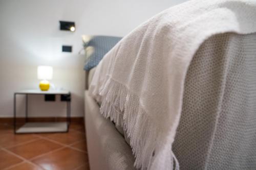 a bed with a white blanket on top of it at B&B La Manica in Milazzo