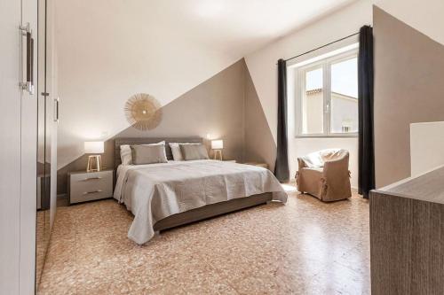 um quarto branco com uma cama grande e uma janela em Elizabeth Guest House em Arzachena