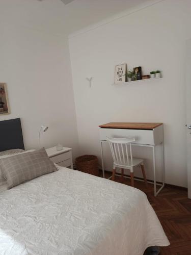 a bedroom with a bed and a desk with a chair at Moderno Depto Pleno Centro in Rosario