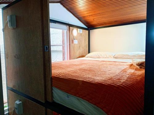 a bedroom with a large bed with a wooden ceiling at Kuyay Hostel in Bogotá