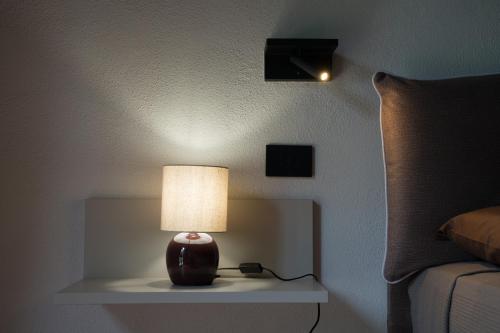 a lamp sitting on a table next to a bed at B&B La Manica in Milazzo