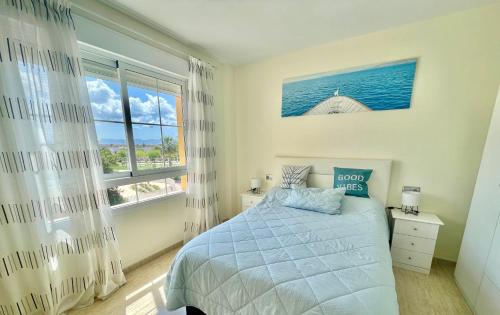 1 dormitorio con cama y ventana grande en Playas de cabo, en Retamar