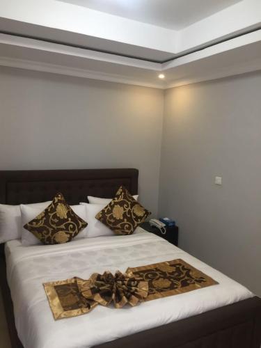 a bedroom with a bed with white sheets and pillows at IZA Serene city centre apartments in Kigali