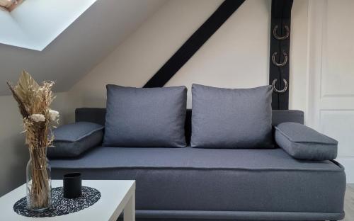 a blue couch with two pillows on a table at Stajnia Tarnowo Pałuckie in Tarnowo Pałuckie