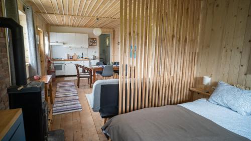 um pequeno quarto com uma cama e uma cozinha em Three Little Birds Artists Residence em Plaški
