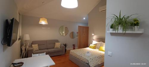 a small living room with a bed and a couch at S Bento Boutique Apartment in Porto