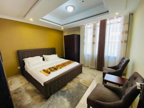 a bedroom with a bed and two chairs at IZA Serene city centre apartments in Kigali