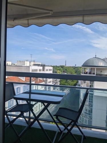 a table and two chairs sitting on a balcony at Superbe STUDIO (28m2) avec terrasse / vue TOUR EIFFEL / PUTEAUX in Puteaux