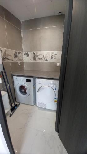 uma casa de banho com uma máquina de lavar roupa e uma máquina de lavar roupa. em Maison Asturiana en bord de forêt 