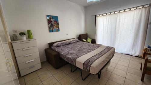 ein Schlafzimmer mit einem Bett, einer Kommode und einem Fenster in der Unterkunft Studio - Sleeps 3 - Pets - Parking - Wifi in Ayia Napa