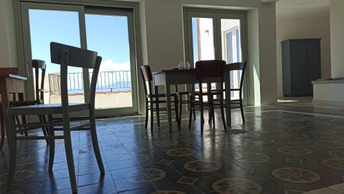 a dining room with a table and chairs and a view of the beach at Monte Forru in Baunei