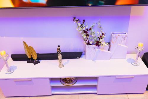 阿克拉的住宿－Piano and Gold at The Signature, Tetteh Quarshie，紫色的桌子上放着花瓶