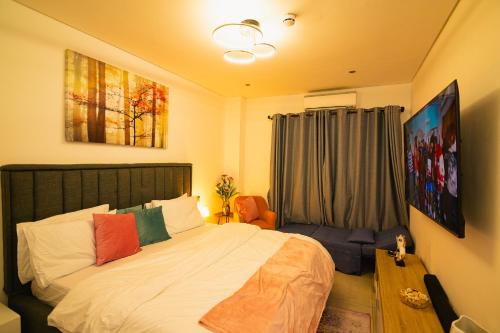 ein Schlafzimmer mit einem großen Bett und einem Fenster in der Unterkunft Piano and Gold at The Signature, Tetteh Quarshie in Accra