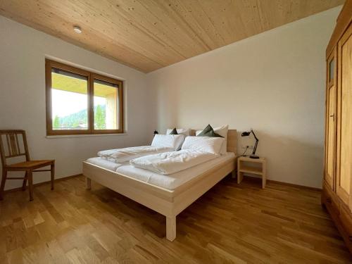 a bedroom with a bed in a room with a window at Gamsfels Petronella Galeriewohnung in Langen bei Bregenz