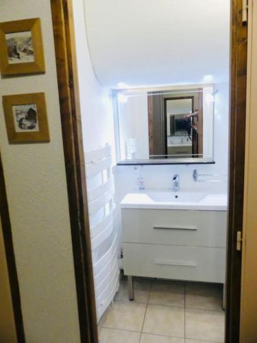 une salle de bain avec un lavabo blanc et un miroir dans l'établissement L'entre 2 Lacs, à Xonrupt-Longemer