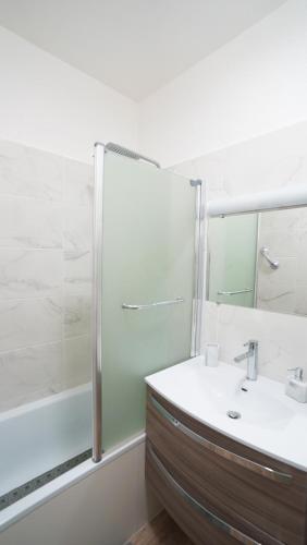 une salle de bain avec un lavabo et une douche dans l'établissement Appartement Les Halles 2, Climatisation, Terrasse, Garage, à Narbonne