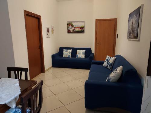 a living room with two blue couches and a table at apartment in the center of Castellammare del Golfo in Castellammare del Golfo