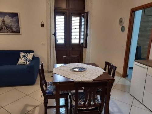 a living room with a table and a blue couch at apartment in the center of Castellammare del Golfo in Castellammare del Golfo