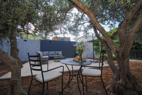 a patio with a table and chairs under a tree at Rooms Dilk in Vis