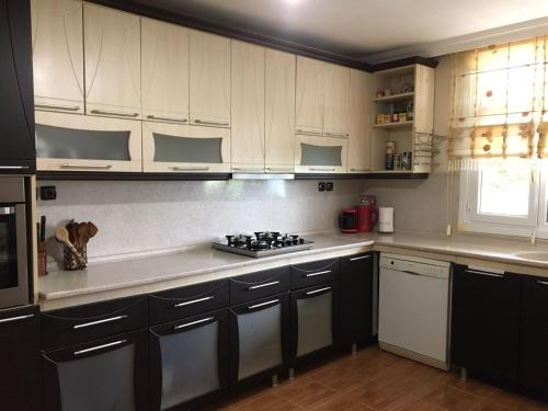 a kitchen with white cabinets and a stove top oven at Kemer Köyü Kır Evi in Cayeli