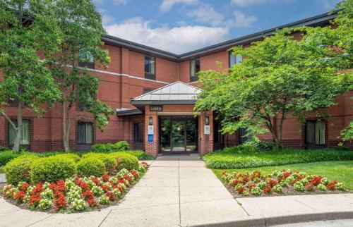 a brick building with flowers in front of it at Extended Stay America Select Suites - Columbia - Gateway Drive in Columbia