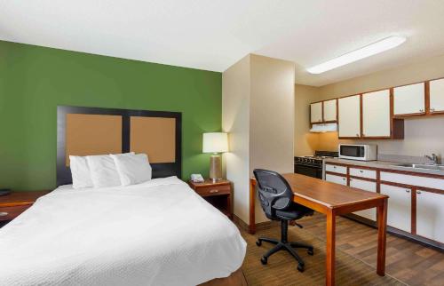 a hotel room with a bed and a desk and a kitchen at Suburban Studios Copley Akron West in Copley