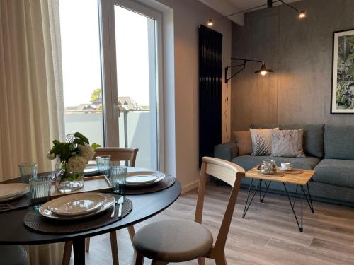 ein Wohnzimmer mit einem Tisch und einem Sofa in der Unterkunft Stylowy Apartament - Port Mielno in Mielno