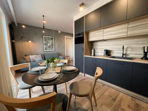 een keuken en eetkamer met een tafel en stoelen bij Stylowy Apartament - Port Mielno in Mielno