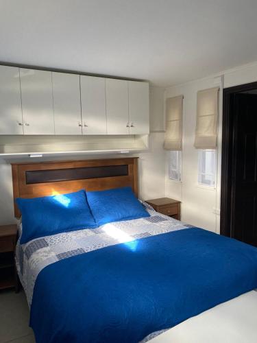 a blue bed with blue pillows in a bedroom at Hostal Florecer in Angol