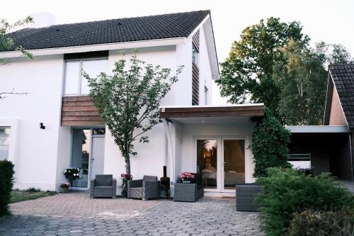 a white house with a courtyard with chairs at Studio Macharen in Macharen