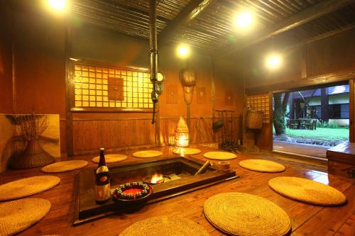 a kitchen with a stove and some wooden stools at Yamashinobu in Minamioguni