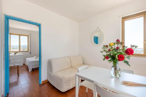 a living room with a vase of flowers on a table at BED BIANCANEVE Attico in Villanova di Ostuni