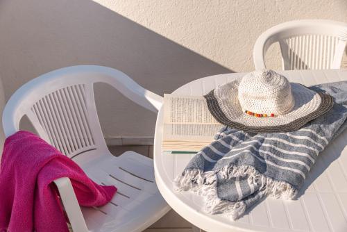 a white chair with a hat and a towel at BED BIANCANEVE Attico in Villanova di Ostuni
