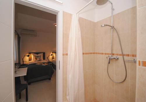 ein Bad mit einer Dusche und ein Schlafzimmer mit einem Bett in der Unterkunft Rooms Dilk in Vis