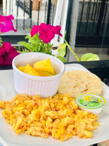 Un plato de comida con un bol de fruta y un plato de pan. en Hotel Carolina Del Mar, en Santa Marta