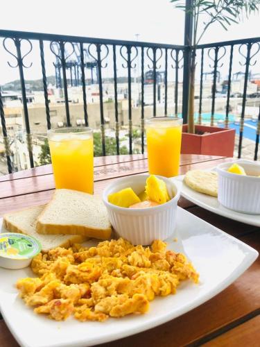 Un plato de comida con huevos, pan y jugo de naranja. en Hotel Carolina Del Mar, en Santa Marta