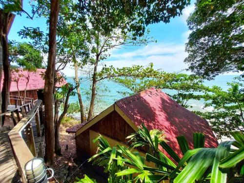 a small house with a red roof in the woods at Jungle Hill Beach Bungalow in Ko Jum