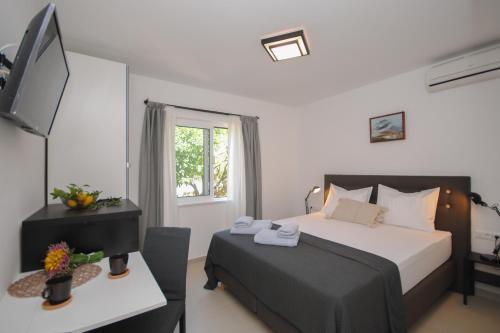 a bedroom with a bed and a desk with a television at Rooms Dilk in Vis