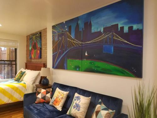 a living room with a couch and a painting on the wall at The Harlem Getaway in New York
