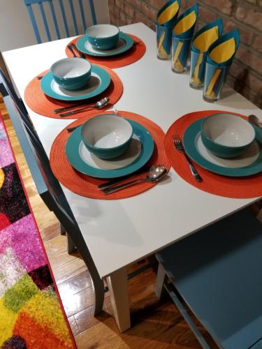 a white table with plates and utensils on it at The Harlem Getaway in New York