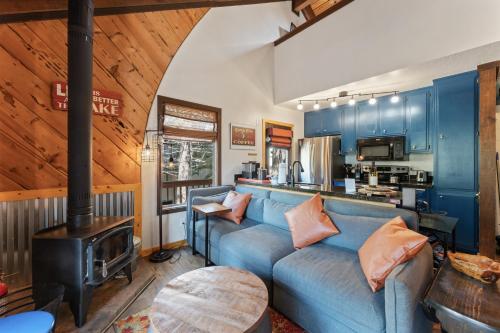 ein Wohnzimmer mit einem blauen Sofa und einem Herd in der Unterkunft The Bear's Den Chalet in Stateline