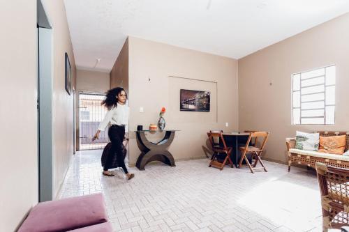 a woman is walking in a living room at Hostel Filhos da Promessa in Tucuruí