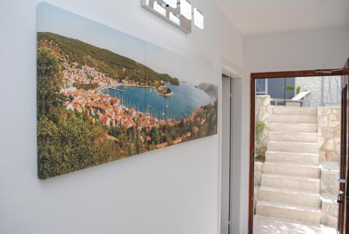 a painting of a village on the side of a mountain at Rooms Dilk in Vis