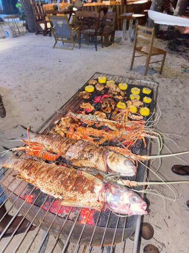 Ein Haufen Fisch wird auf einem Grill gekocht in der Unterkunft Dhiffushi Island Villa in Dhiffushi
