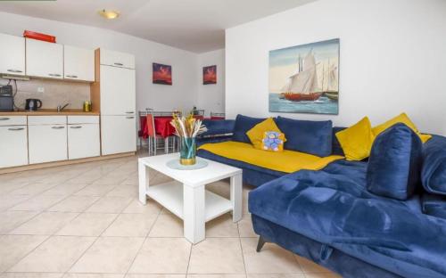 a living room with a blue couch and a table at Apartments Petrovic in Rogoznica