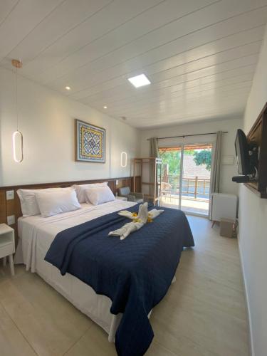 a bedroom with a large bed with a blue blanket at Pousada do Nativo in Fernando de Noronha